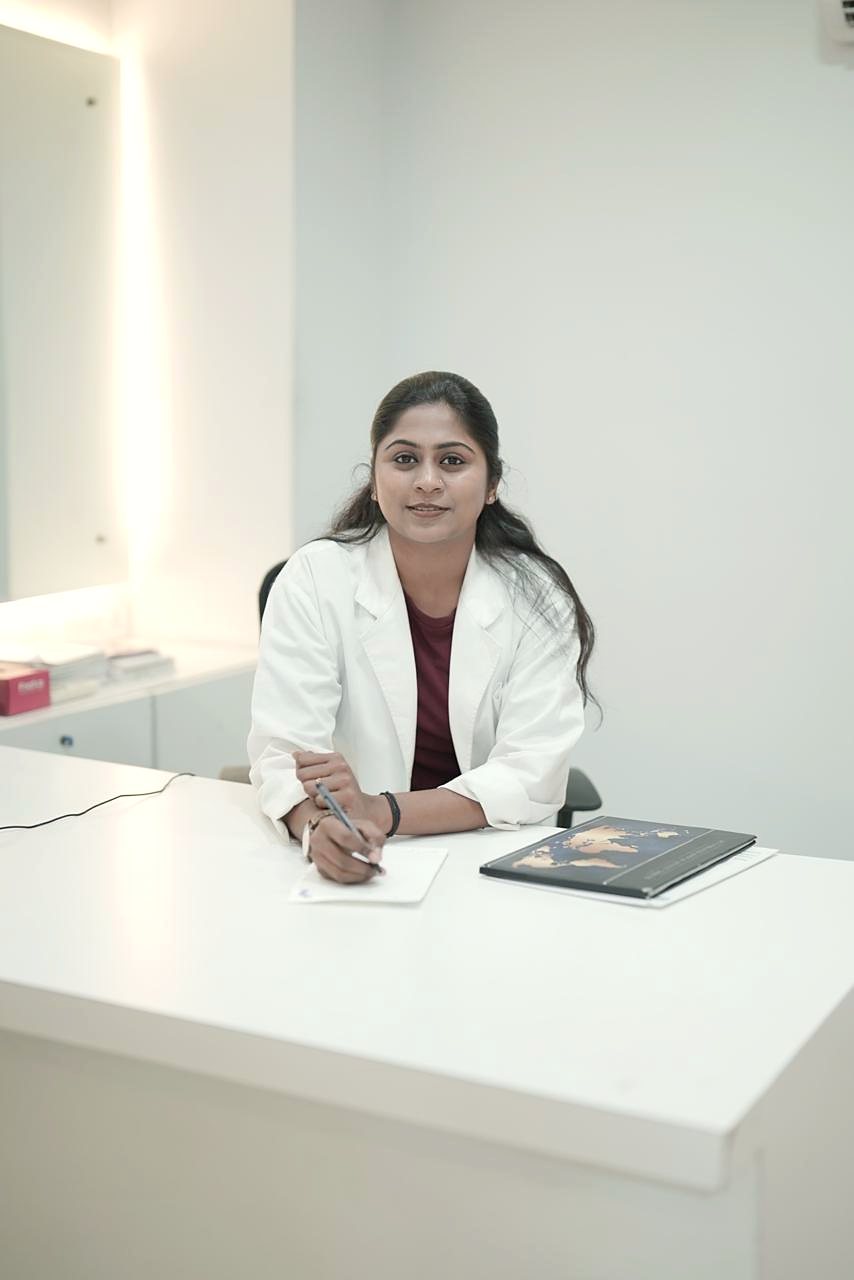 Dr. Aiswaryia Mohan at her consultation desk in a white coat