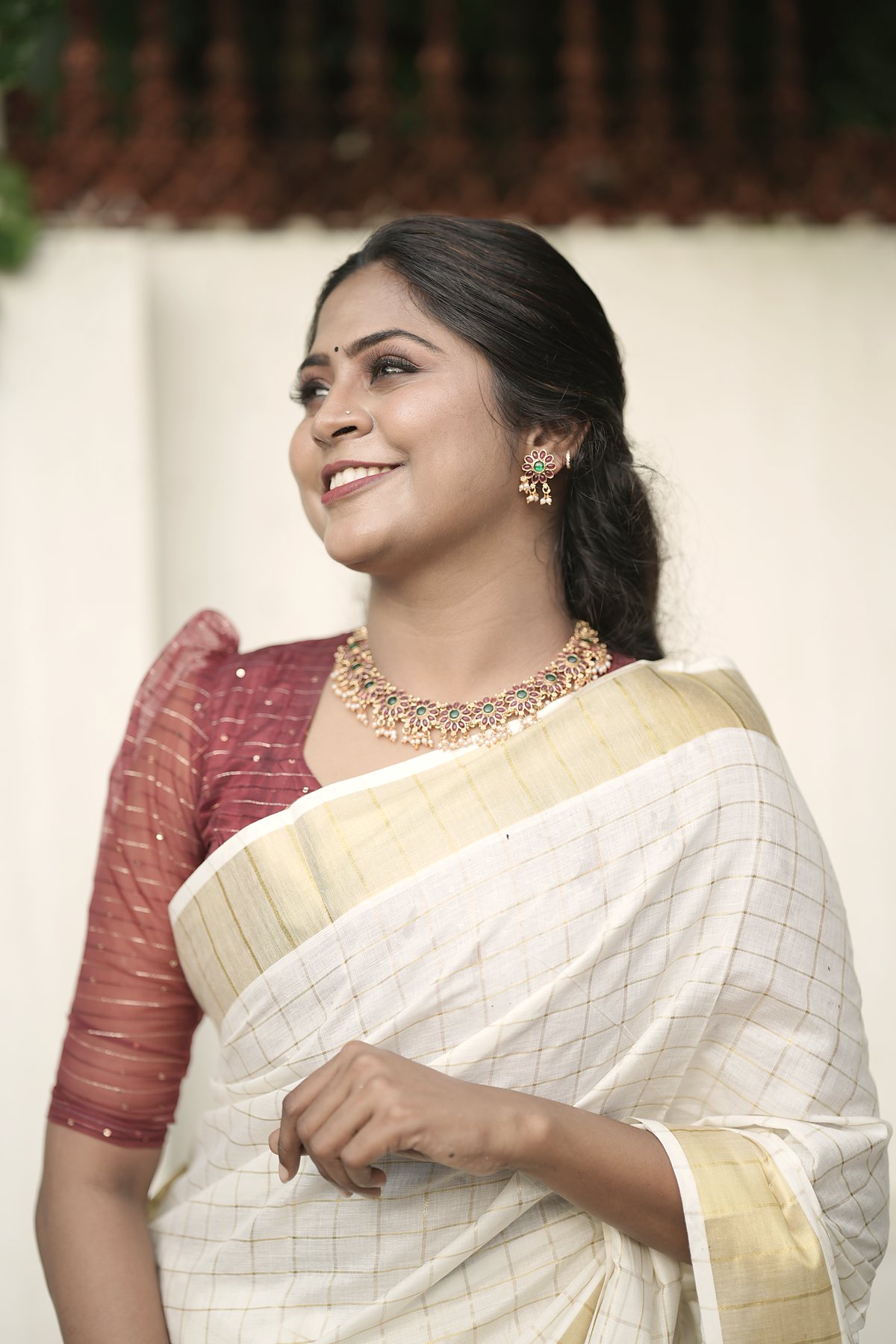 Dr Aiswaryia Mohan smiling in a traditional Kerala kasavu saree